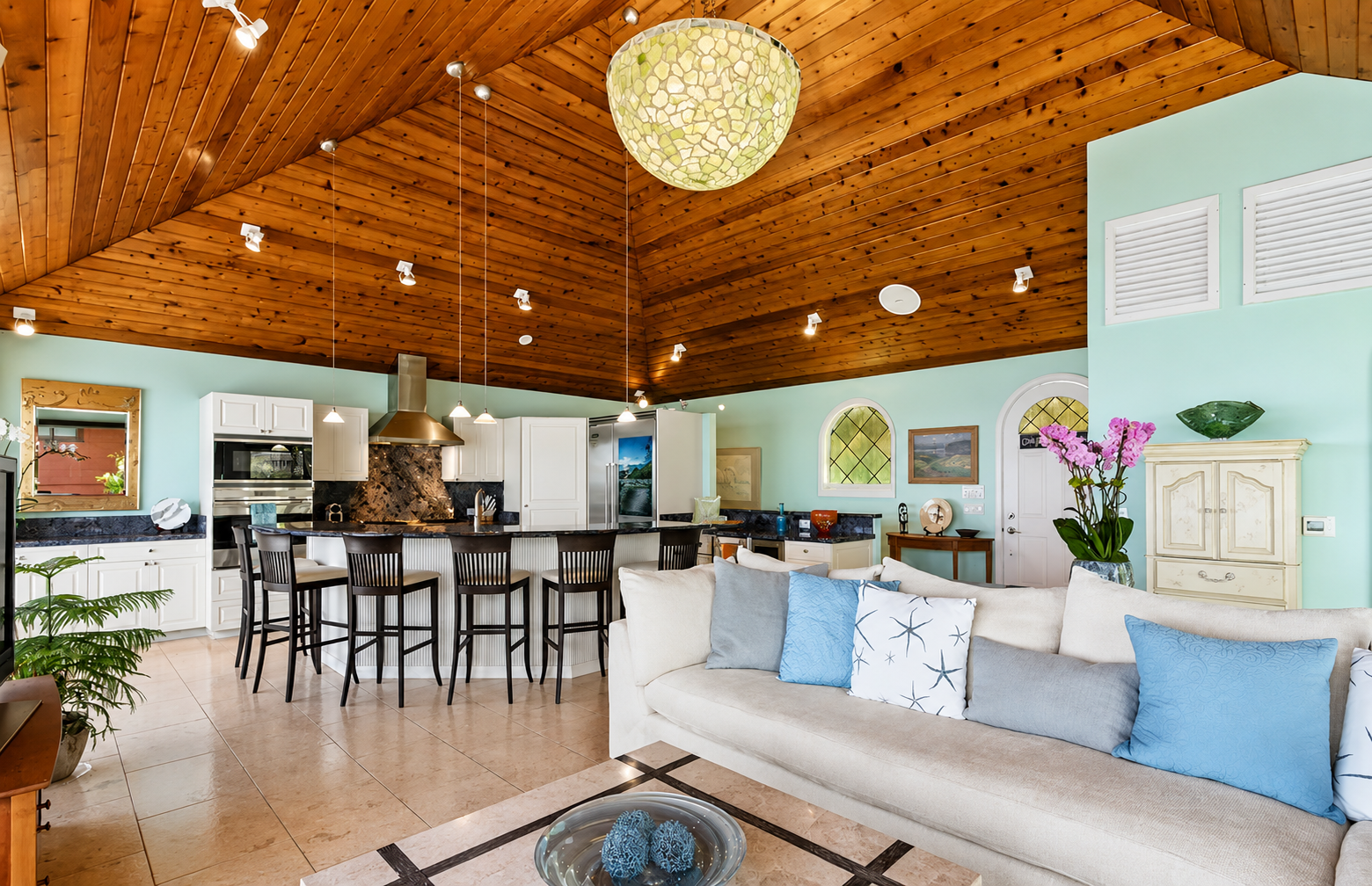 Open living room and kitchen with vaulted wood ceiling inside Mermaid Cottage